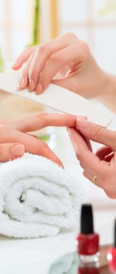 Woman in a nail salon receiving a manicure by a beautician